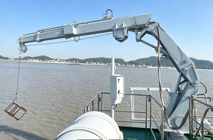 Telescopic knuckle-boom crane lifting equipment over the side